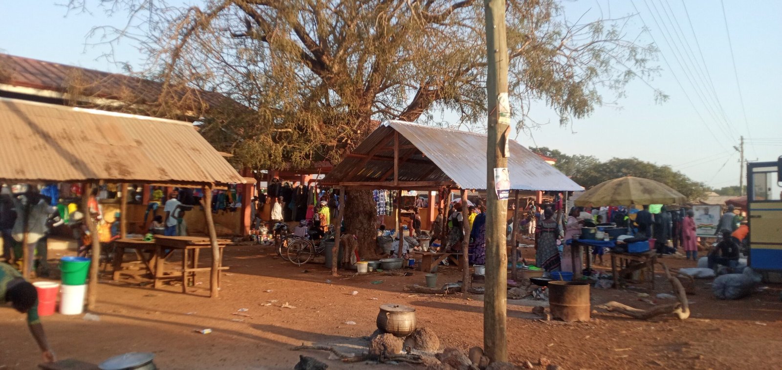 a group of people standing around a tenta, rural market and station market and a station