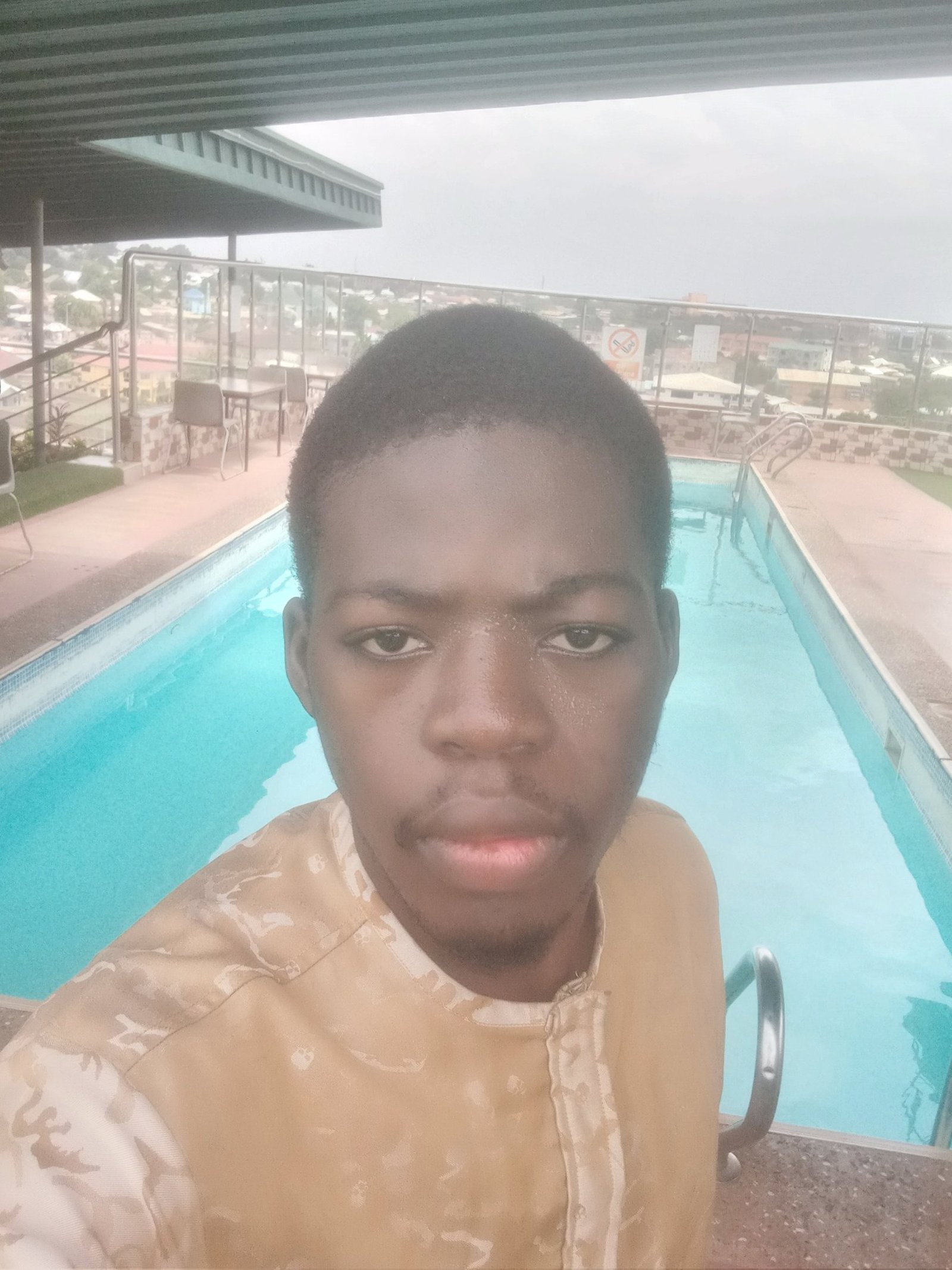 a young man standing in front of a swimming pool