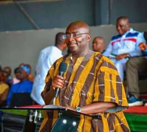 Dr. Mahamudu Bawumia is the man in a yellow shirt and glasses speaking into a microphone about Ghana