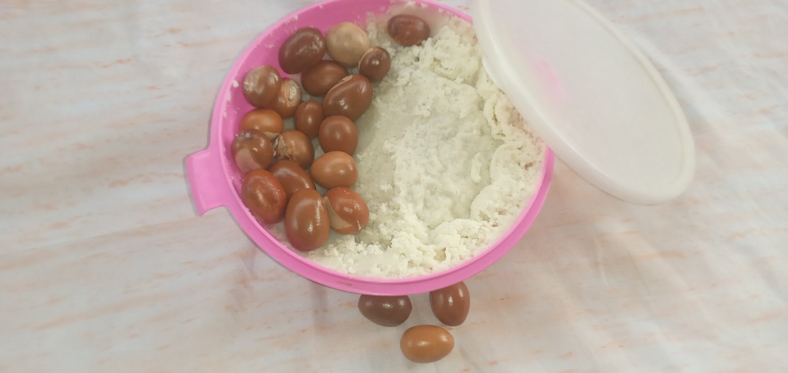 shea nuts and shea butter in a  pink bowl